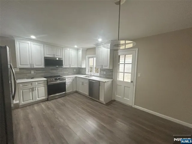 a kitchen with a white cabinets sink and stainless steel appliances