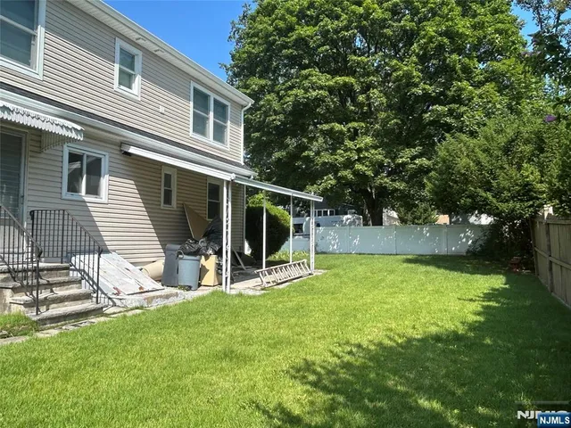 a view of a house with backyard and a tree