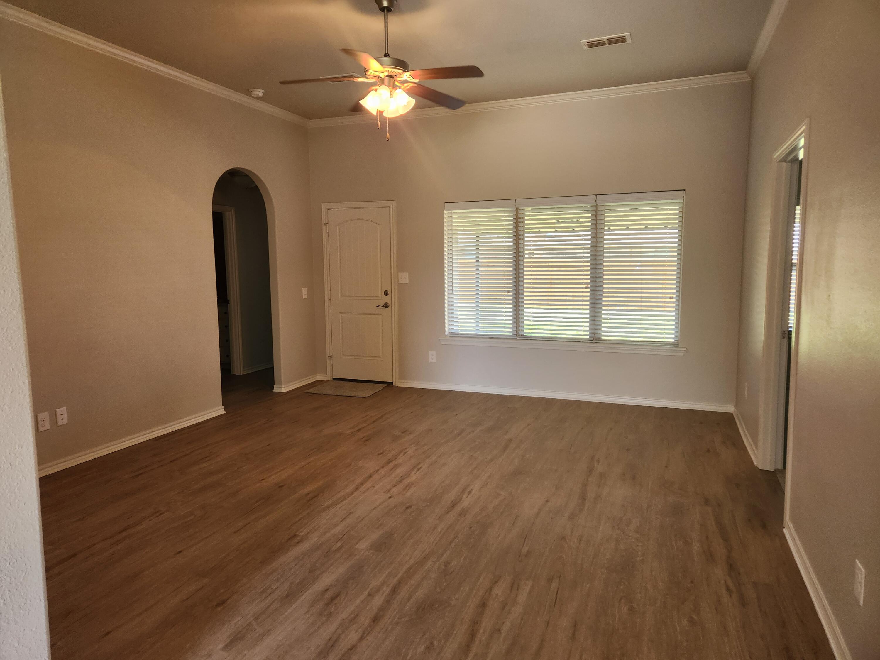 8702 13th Street Lubbock, TX 79416 - Photo 2 of 25 a view of an empty room with wooden floor and a window