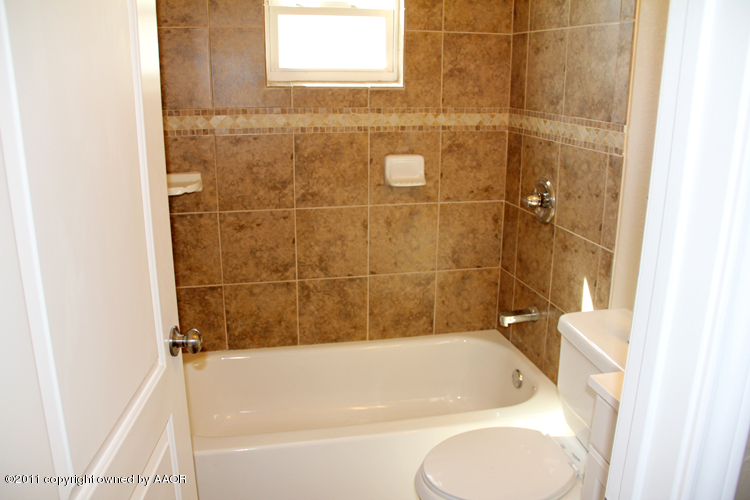 4612 Parker Street Amarillo, TX 79110 - Photo 13 of 17 a bathroom with a bathtub and a shower