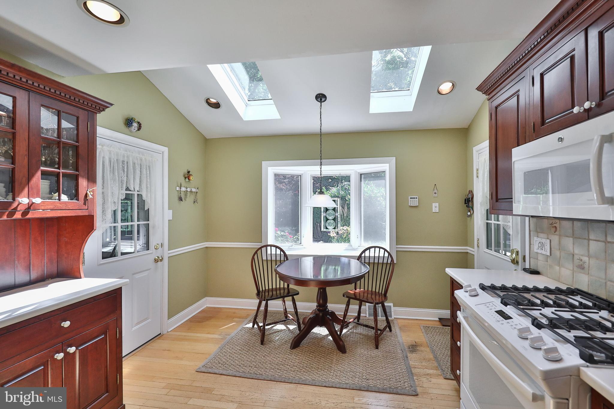 1324 Barrowdale Road Jenkintown, PA 19046 - Photo 22 of 44 a kitchen with stainless steel appliances granite countertop a stove a sink dishwasher a dining table and chairs with wooden floor