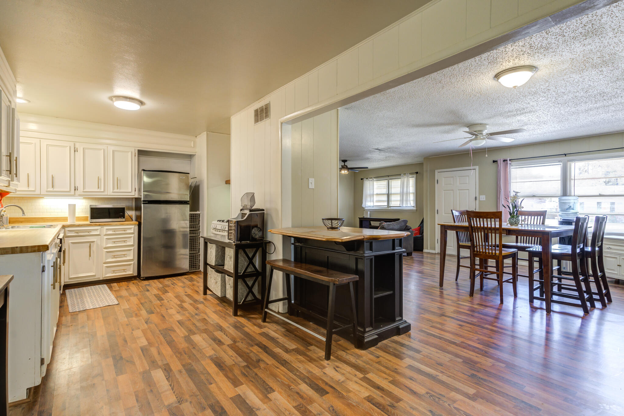 2812 62nd Street Lubbock, TX 79413 - Photo 3 of 45 a kitchen with stainless steel appliances granite countertop a stove top oven a sink dishwasher a dining table and chairs with wooden floor