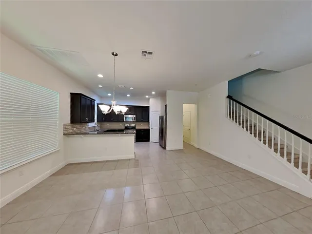 a large kitchen with stainless steel appliances granite countertop a refrigerator a oven a sink and a granite counter tops