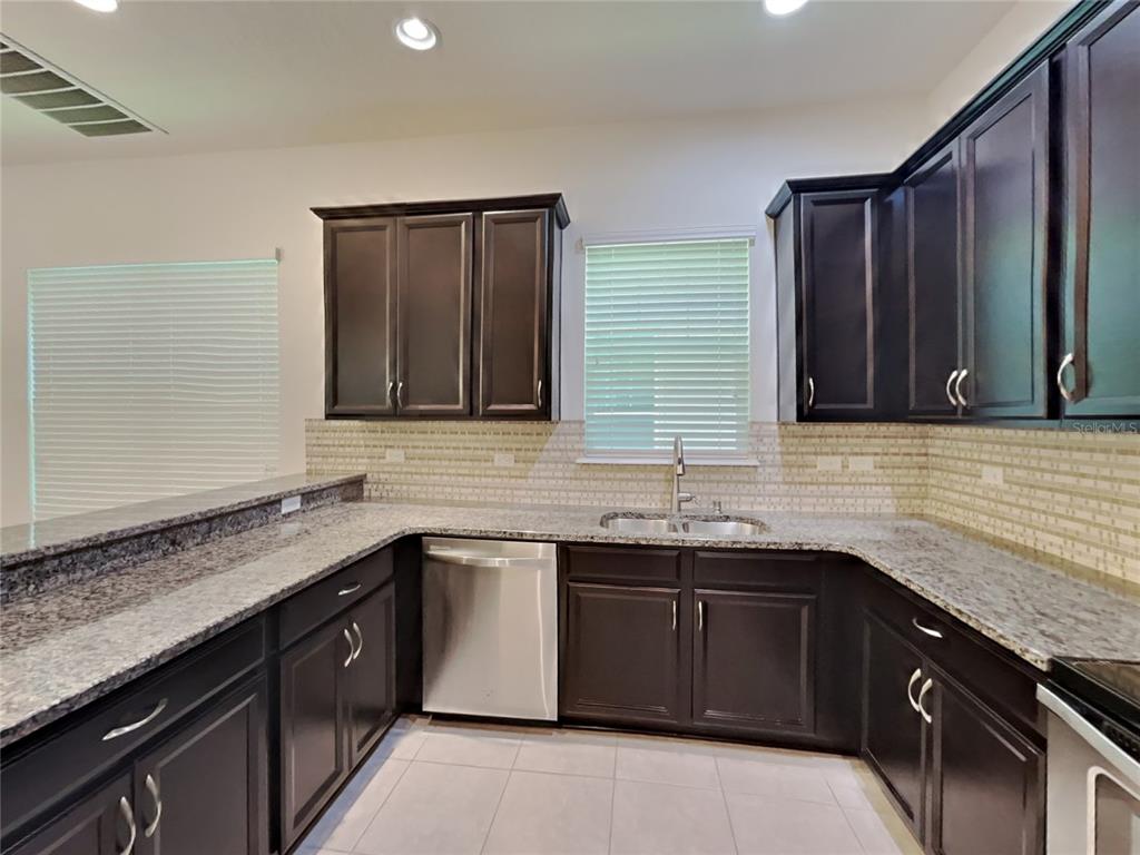 8326 Bryce Canyon Avenue Windermere, FL 34786 - Photo 7 of 20 a kitchen with stainless steel appliances granite countertop a sink stove and cabinets