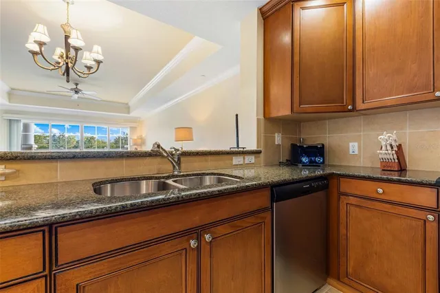a kitchen with stainless steel appliances granite countertop a sink a stove and cabinets