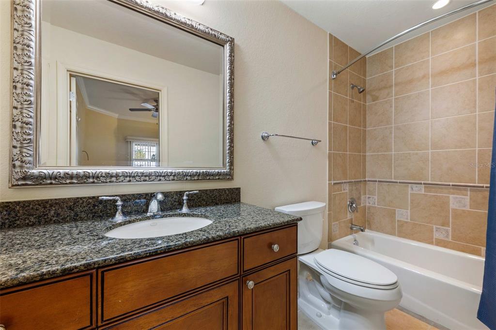 7612 Cabana Court, Unit 303 Reunion, FL 34747 - Photo 21 of 23 a bathroom with a granite countertop sink toilet mirror and shower