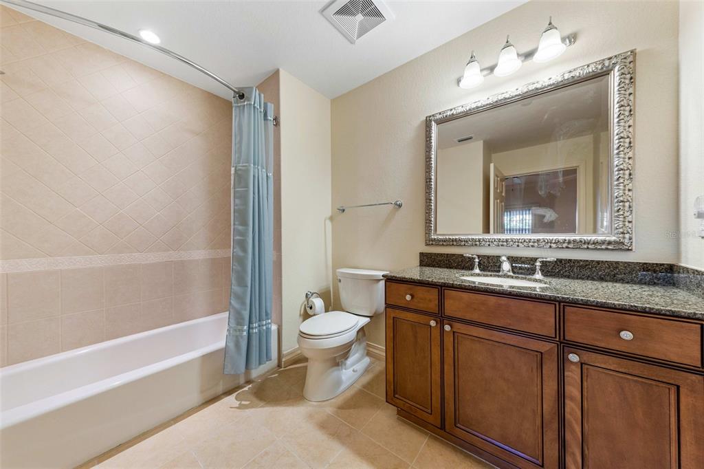 7612 Cabana Court, Unit 303 Reunion, FL 34747 - Photo 6 of 23 a bathroom with a granite countertop sink mirror vanity bathtub and a toilet