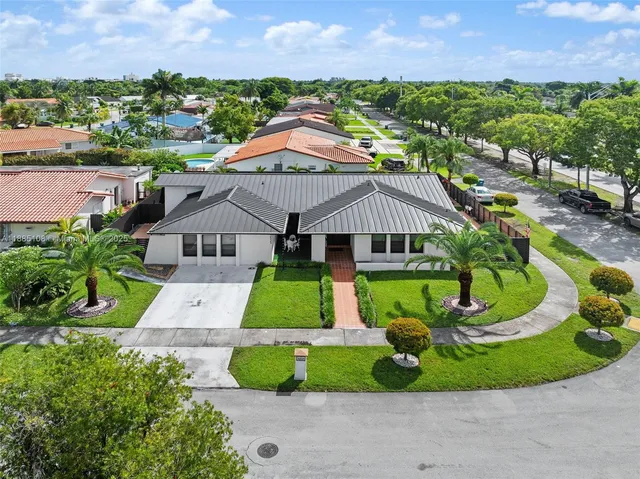 a aerial view of a house with a big yard and potted plants
