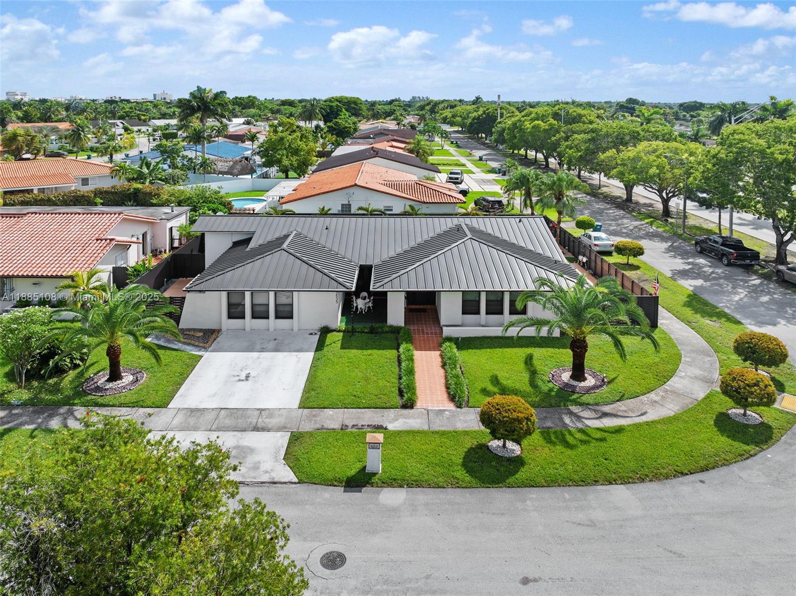a aerial view of a house with a big yard and potted plants