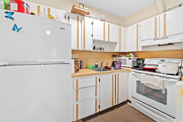 a kitchen with white cabinets and white appliances