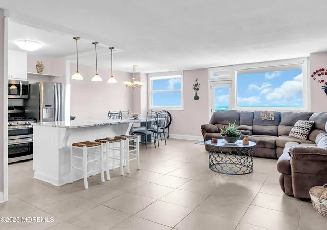a living room with furniture and kitchen view