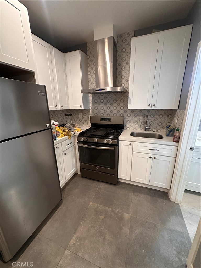 8963 Mercedes Avenue Arleta, CA 91331 - Photo 5 of 7 a kitchen with granite countertop white cabinets and white appliances