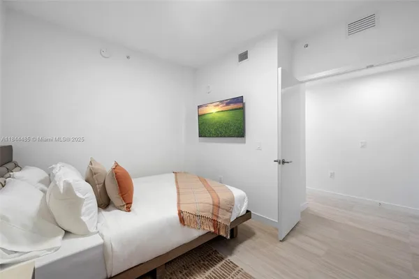 a bedroom with a bed and a flat screen tv