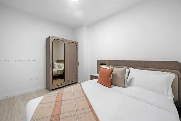 a bedroom with a bed and a mirror