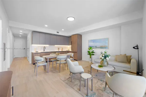 a living room with furniture and a dining table with kitchen view