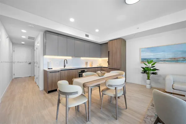 a kitchen with stainless steel appliances kitchen island granite countertop a table and chairs in it