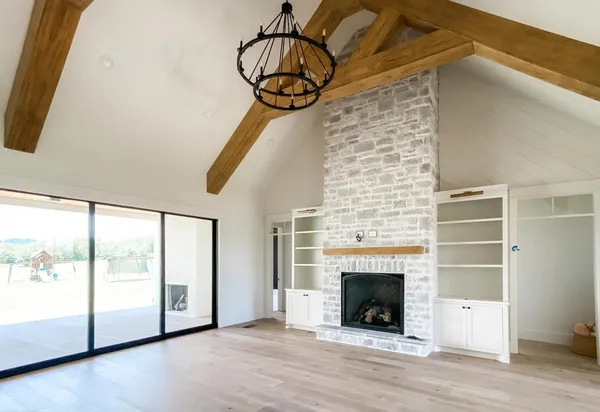 a view of a livingroom with wooden floor a fireplace and window