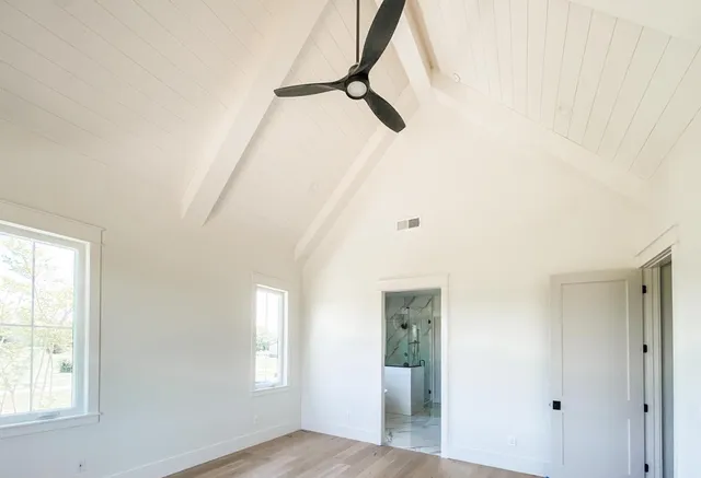 a view of a room with wooden floor and a bathroom