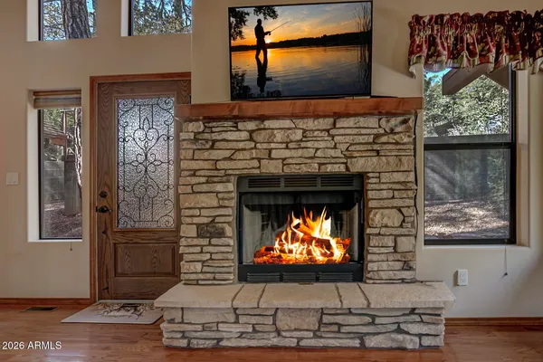 a view of a livingroom with a fireplace a ceiling fan and brick wall