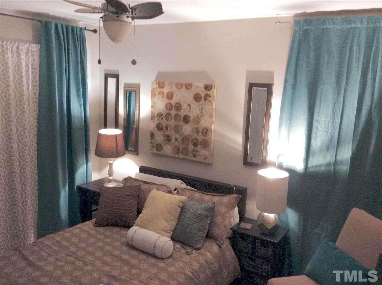 309 Avon Drive Raleigh, NC 27608 - Photo 13 of 17 a bed room with a bed and a painting on the wall