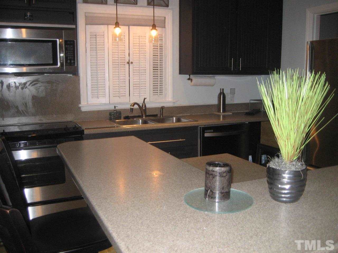 309 Avon Drive Raleigh, NC 27608 - Photo 6 of 17 a kitchen with a sink and a microwave