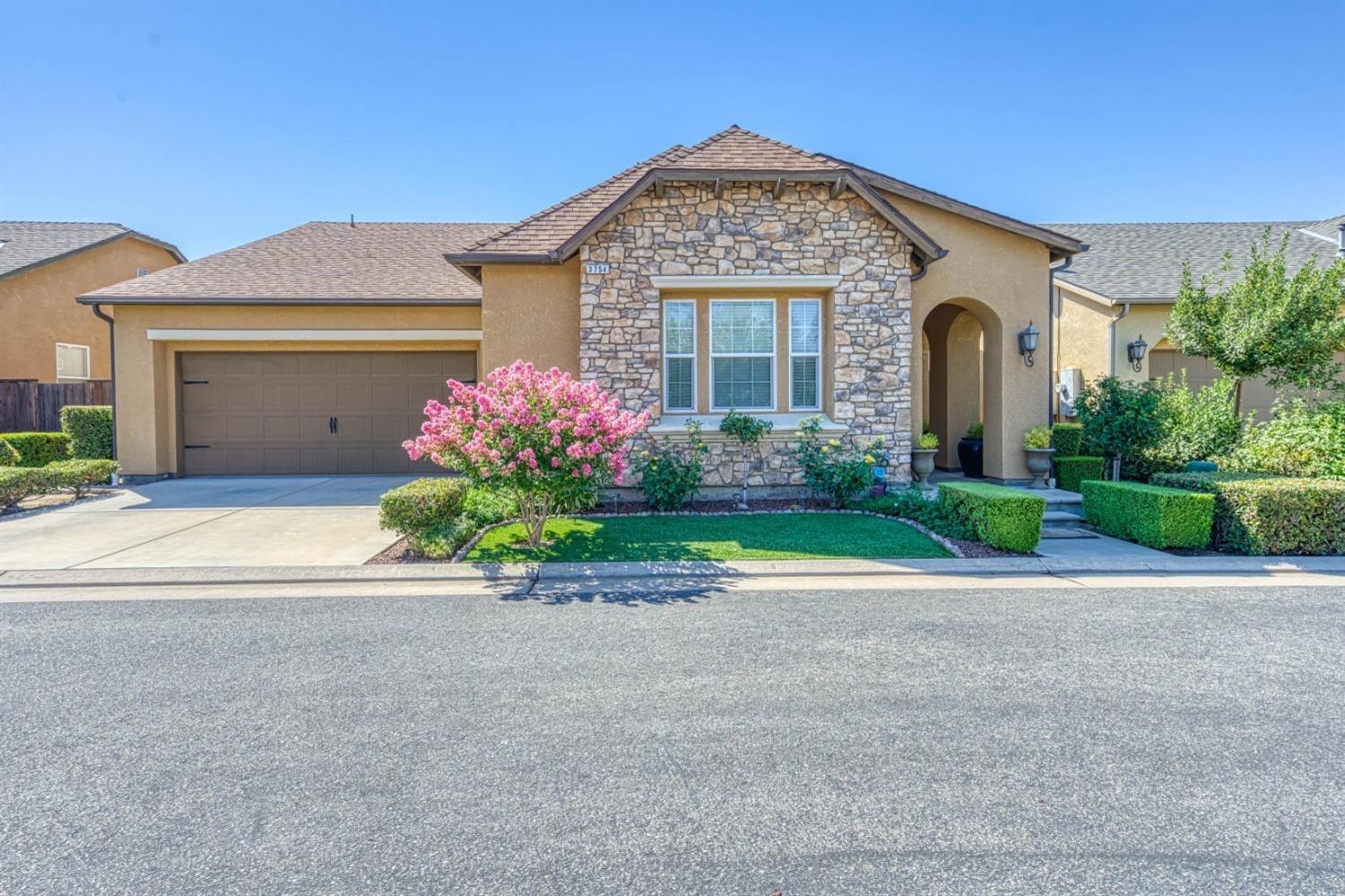 a front view of a house with a garden and mountain view