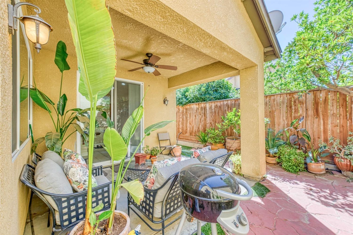 3754 Salem Lane Clovis, CA 93619 - Photo 15 of 18 a view of a patio with table and chairs potted plants and wooden fence