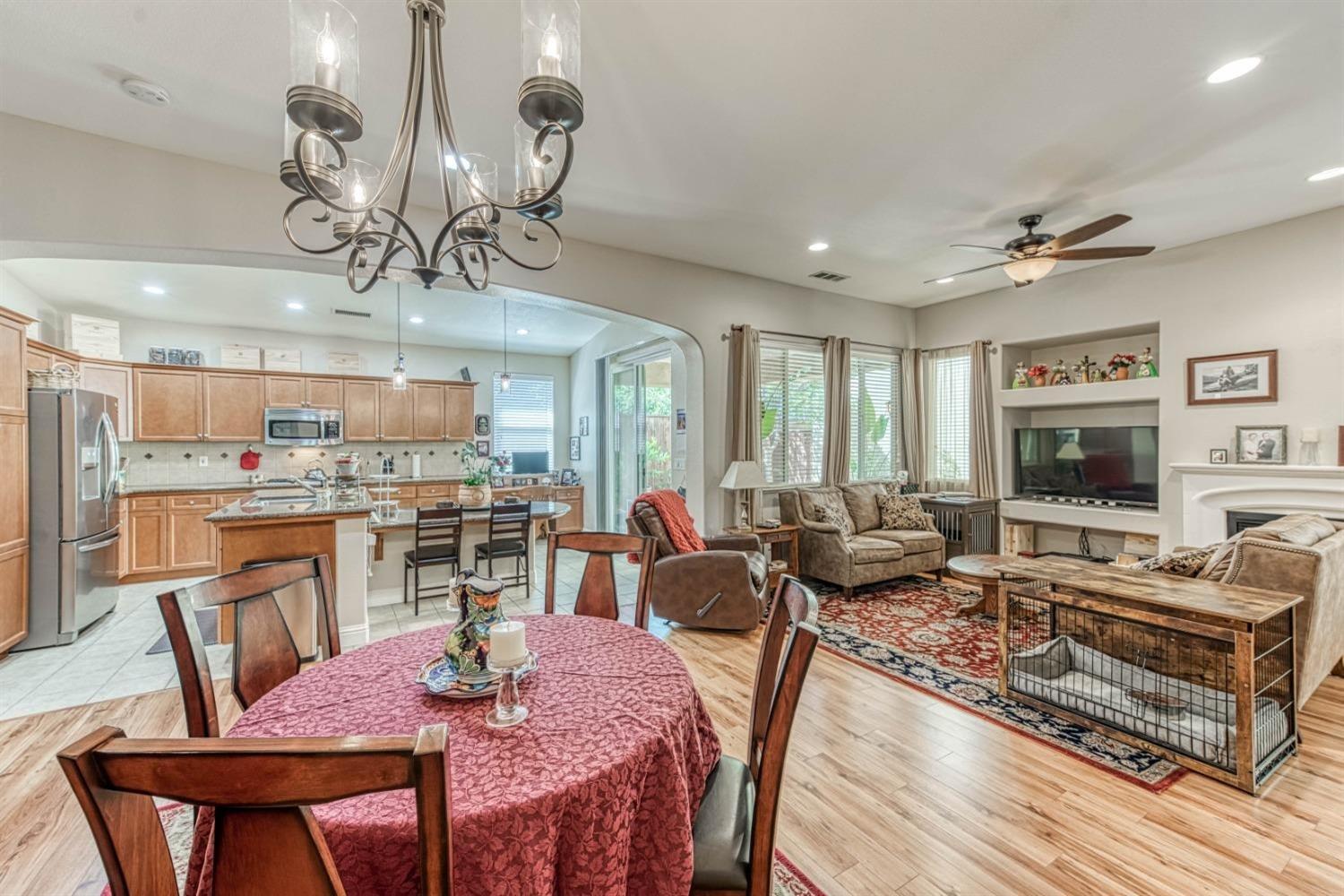 3754 Salem Lane Clovis, CA 93619 - Photo 4 of 18 a view of a dining room with furniture a chandelier and wooden floor
