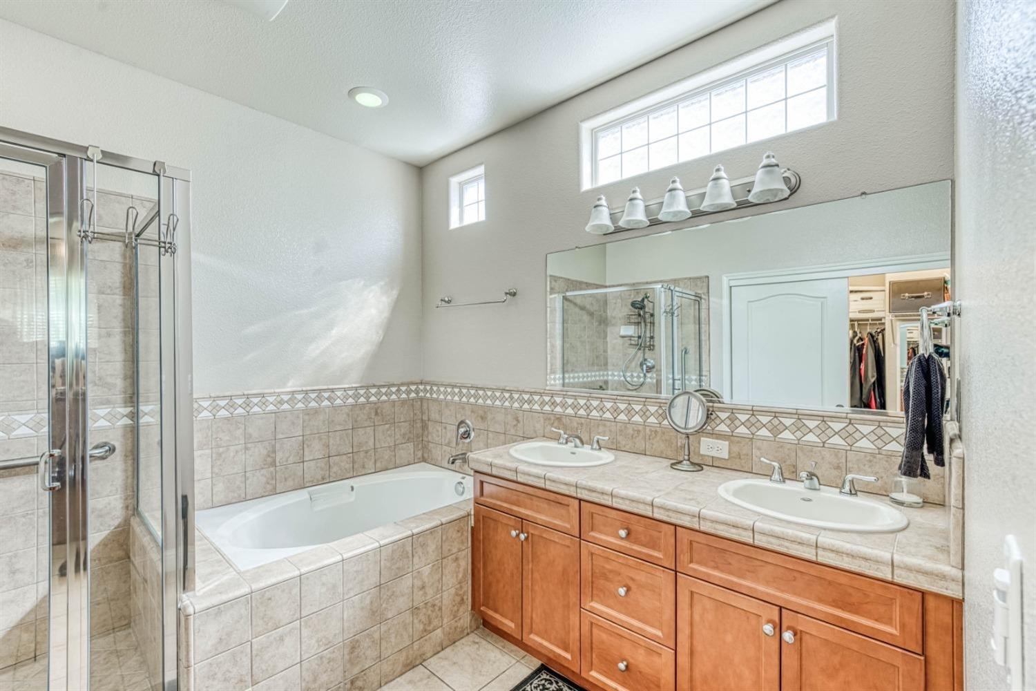3754 Salem Lane Clovis, CA 93619 - Photo 8 of 18 a bathroom with a tub a sink and a mirror