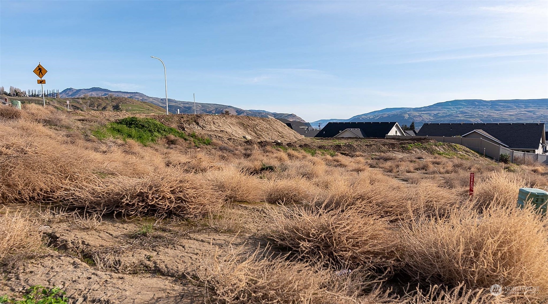 982 Spring Mountain Drive Wenatchee, WA 98801 - Photo 2 of 6 a view of a dry yard with mountains in the background