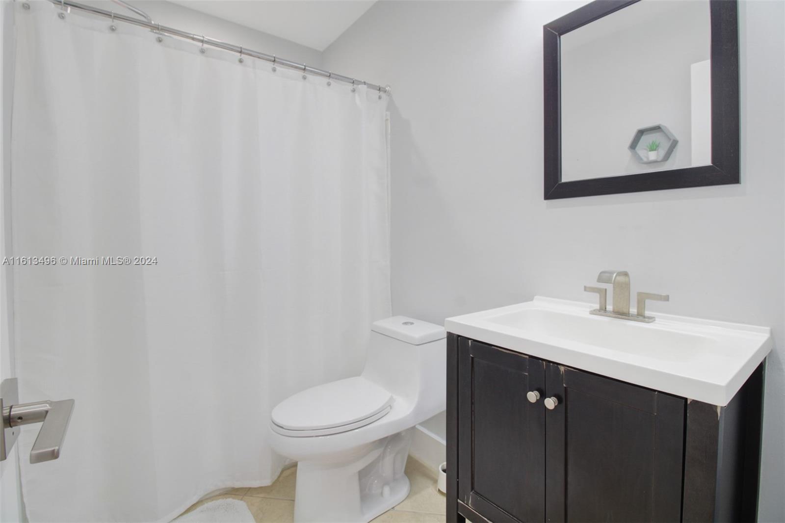 9730 Southwest 76th Street Miami, FL 33173 - Photo 12 of 27 a bathroom with a toilet sink vanity and mirror