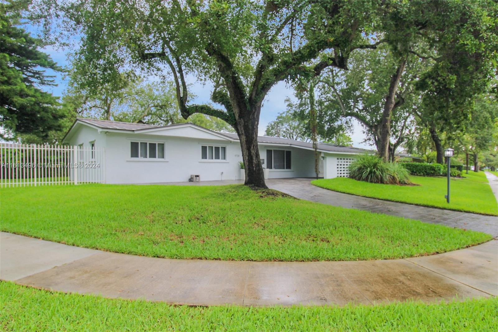 9730 Southwest 76th Street Miami, FL 33173 - Photo 18 of 27 a front view of a house with a garden and yard