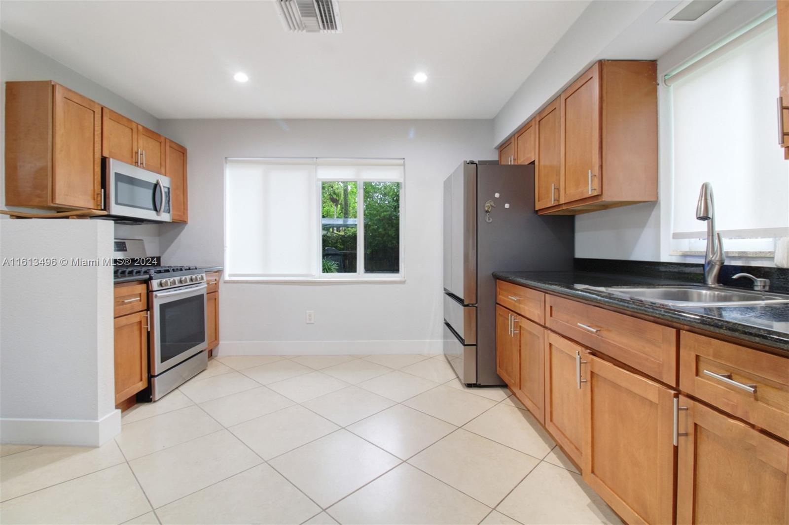 9730 Southwest 76th Street Miami, FL 33173 - Photo 2 of 27 a kitchen with stainless steel appliances granite countertop a refrigerator and a stove top oven