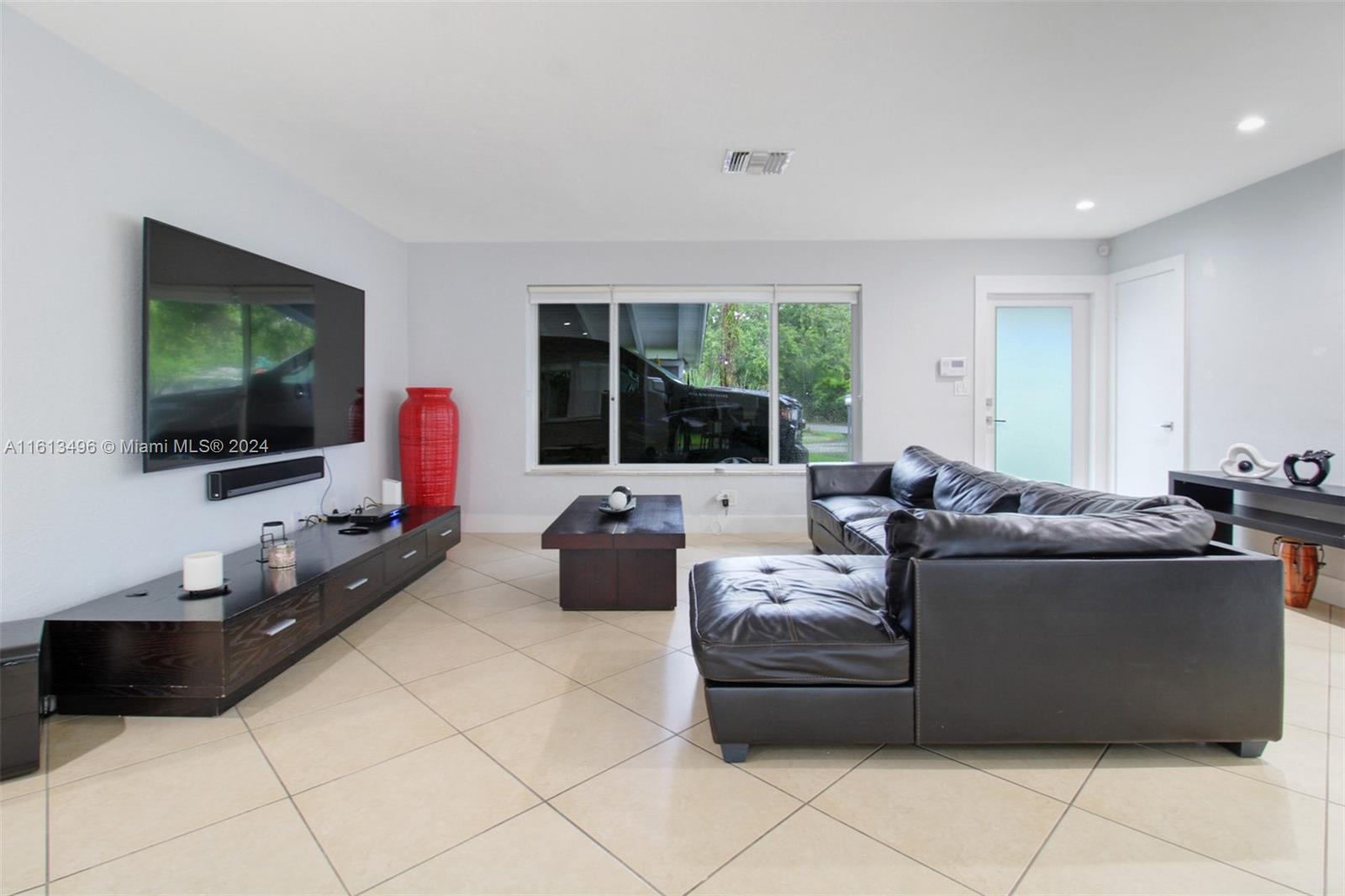 9730 Southwest 76th Street Miami, FL 33173 - Photo 4 of 27 a living room with furniture and a flat screen tv