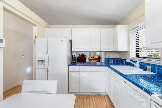 a kitchen with granite countertop white cabinets and white appliances