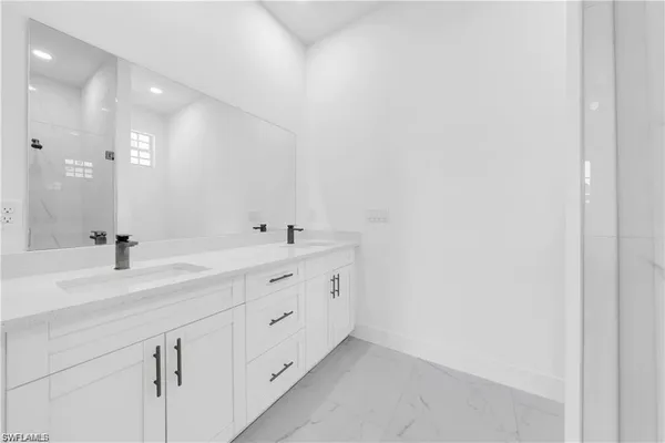 a bathroom with a double vanity sink and mirror