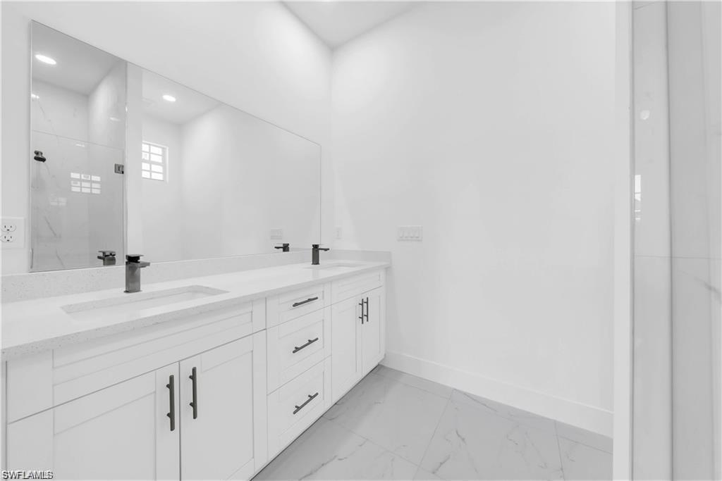 3310 11th Street West Lehigh Acres, FL 33971 - Photo 17 of 20 a bathroom with a double vanity sink and mirror