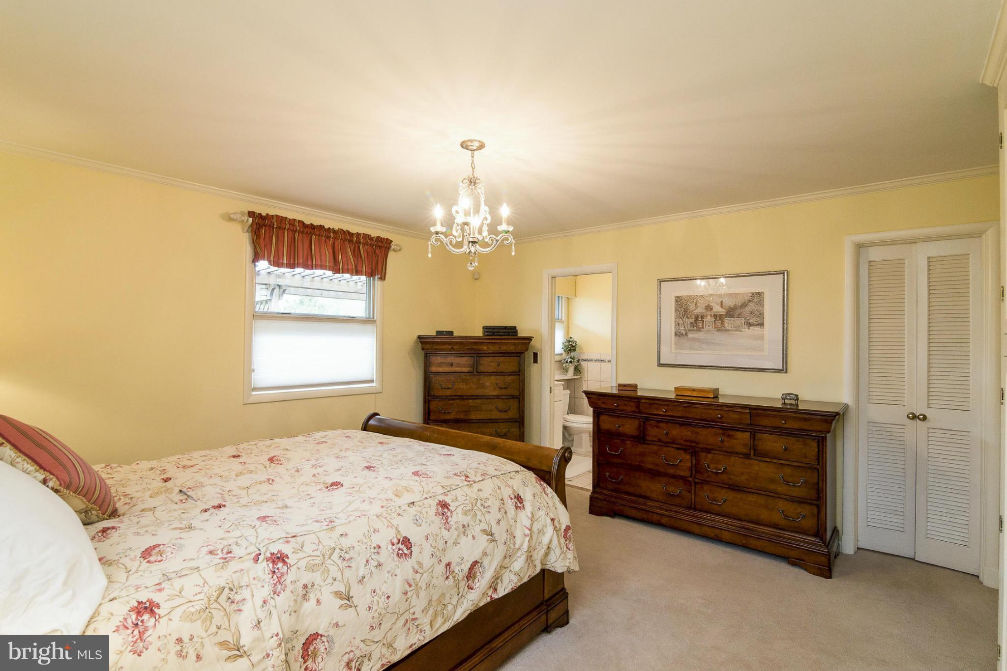 1200 Doves Cove Road Baltimore, MD 21286 - Photo 12 of 25 a bedroom with a bed and dresser with mirror