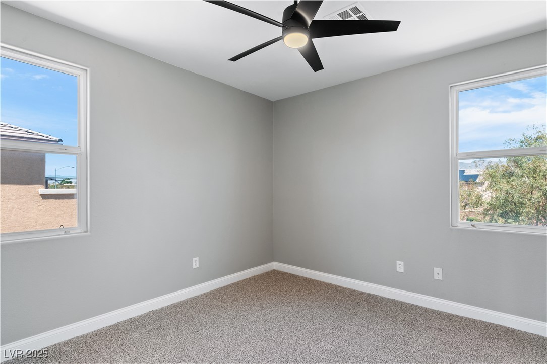 312 Pocono Ranch Avenue North Las Vegas, NV 89031 - Photo 26 of 34 Spare room with a ceiling fan, visible vents, carpet, and baseboards