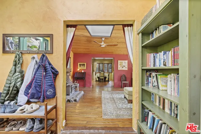 a dining hall with couches a dining table and chairs with wooden floor