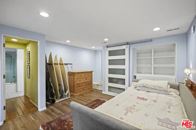 a bedroom with a bed and wooden floor