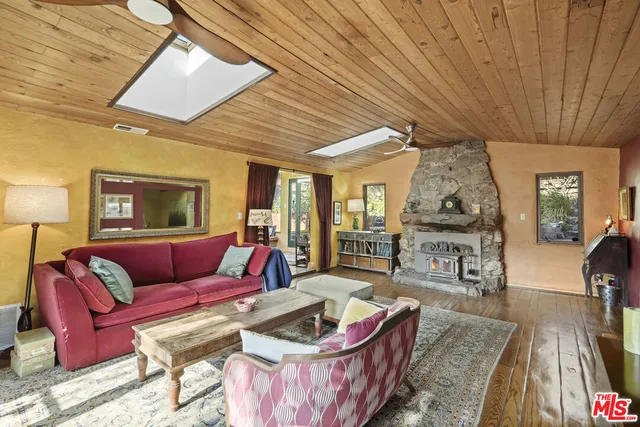 a living room with furniture a rug a fireplace and a large window