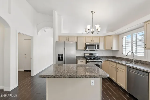 a kitchen with a center island wooden floor and a chandelier