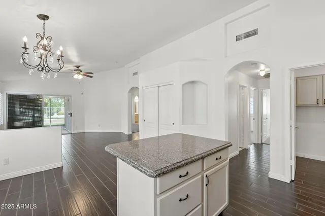 a kitchen with stainless steel appliances granite countertop a sink dishwasher a refrigerator and a stove with wooden floor