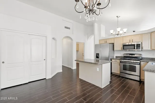 a kitchen with granite countertop a sink stainless steel appliances and cabinets