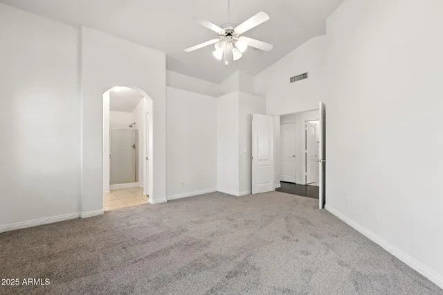 an empty room with windows and fan