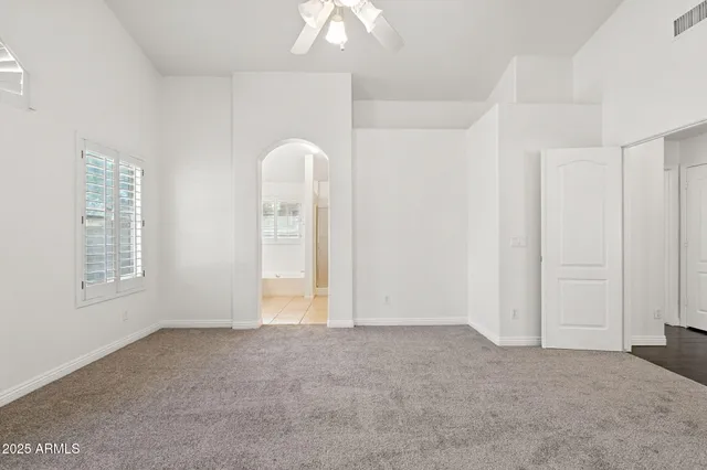an empty room with fan and a ceiling fan
