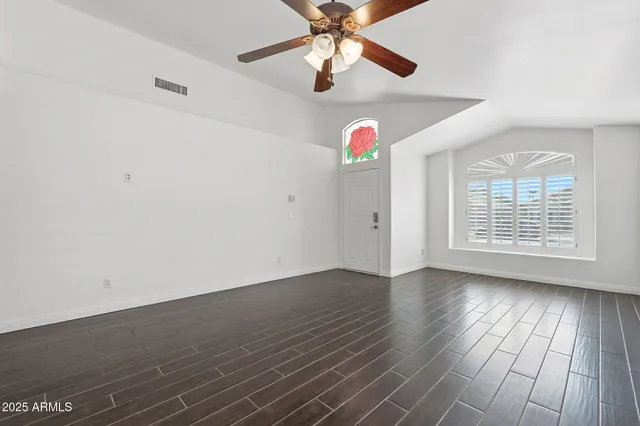 a view of empty room with wooden floor