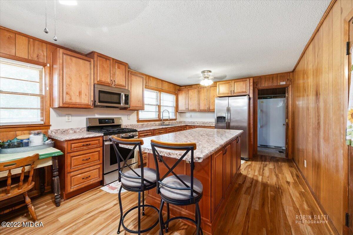 1979 Bonner Gilbert Road Macon, GA 31220 - Photo 6 of 35 a kitchen with stainless steel appliances granite countertop a stove top oven a sink dishwasher and wooden cabinets with wooden floor