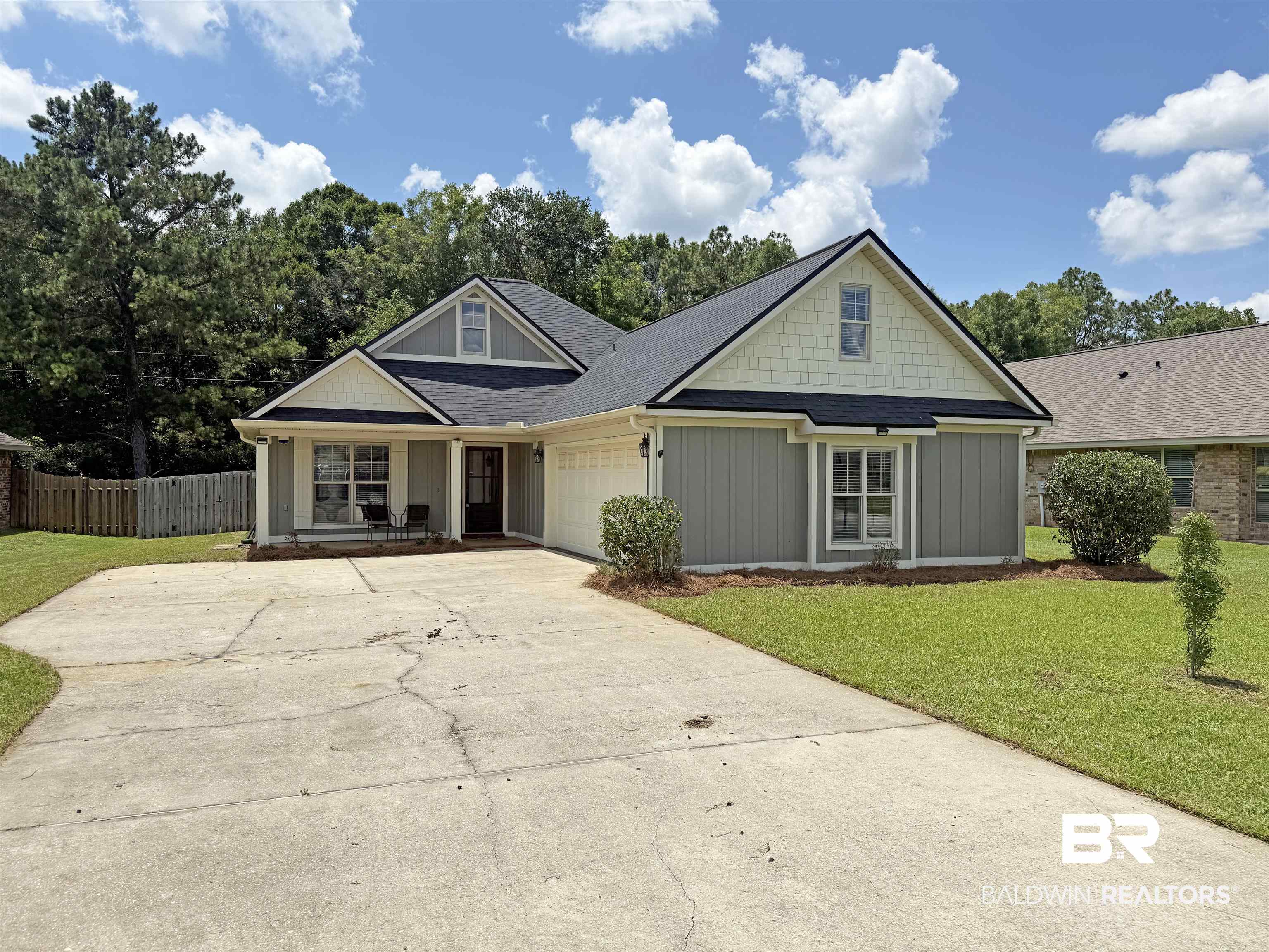 22023 Garland Loop Silverhill, AL 36576 - Photo 33 of 33 View of front facade featuring concrete driveway, board and batten siding, an attached garage, covered porch, and a shingled roof